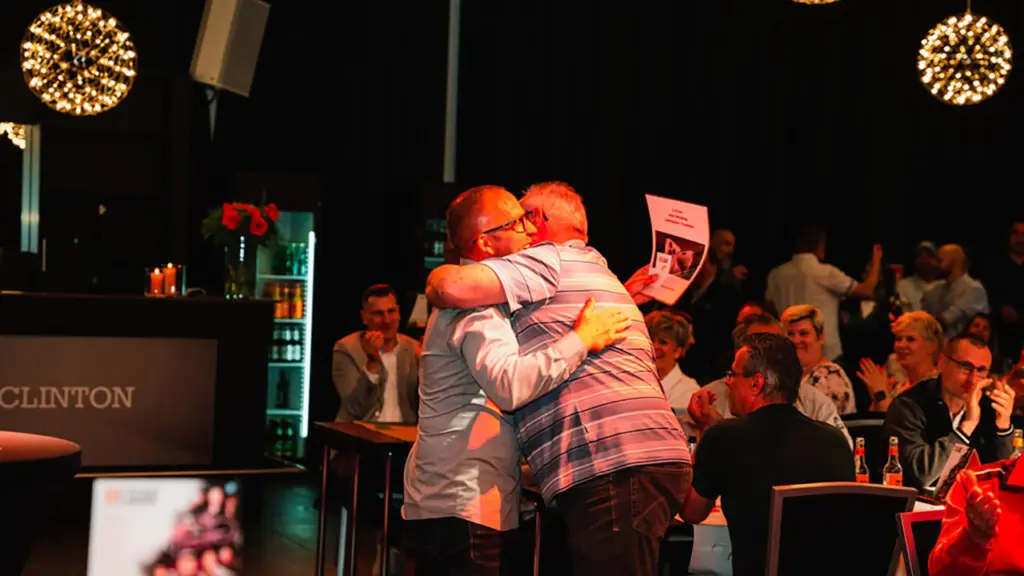 Das Bild zeigt zwei Mitarbeiter der BSU, die sich umarmen.