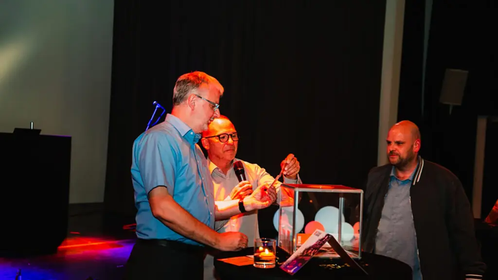 Das Bild zeigt einige Mitarbeiter, die an einem Tombola-Gewinnspiel teilnehmen.